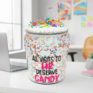 May include: A large glass jar filled with pastel-colored candies, topped with a swirl of white frosting and colorful candies. The jar is decorated with the text "ALL VISITS TO HR DESERVE CANDY". A fun and whimsical office or home decor item.