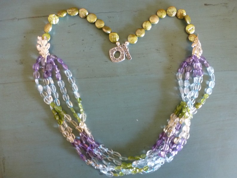 Soft Dreams Necklace is 5 strands of pastel oval gems gathered into brushed silver oak leaves and coin pearls and secured by a silver toggle