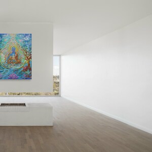 May include: A colorful painting of a blue figure sitting in a lotus position surrounded by flowers and trees. The painting is framed and hanging on a white wall in a modern room.