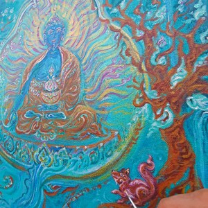 May include: A painting in progress of a blue Buddha figure sitting in a meditative pose with a golden halo. The Buddha is surrounded by swirling blue and gold patterns. A small pink animal is being painted on the right side of the canvas.
