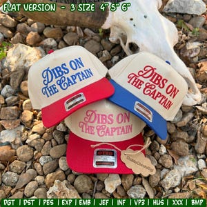 May include: Three baseball caps with cream-colored crowns and colored brims. Each cap features the embroidered text DIBS ON THE CAPTAIN. One cap has a red brim and blue text, one has a blue brim and red text, and one has a red brim and pink text.