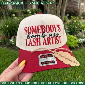 Könnte beinhalten: Eine cremefarbene Baseballkappe mit rotem Schirm und dem gestickten rot-schwarzen Text 'SOMEBODY'S bomb ass LASH ARTIST'. Die Kappe hat einen Aufkleber auf dem Schirm und ein braunes, wolkenförmiges Etikett mit der Aufschrift 'ChubbyCheeksDigi'.