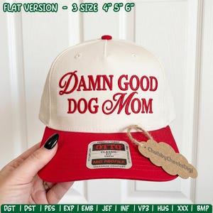 May include: A cream-colored baseball cap with a red brim and red embroidered text that reads "DAMN GOOD DOG MOM". The cap features a sticker on the brim and a brown cardboard tag attached with twine. The text "FLAT VERSION - 3 SIZE 4" 5" 6"" appears above.