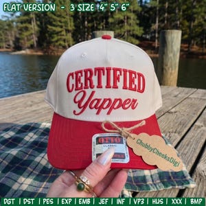 Peut inclure: Une casquette de baseball couleur crème avec une visière rouge et le texte "CERTIFIED Yapper" brodé en rouge sur le devant. Une étiquette en papier brun en forme de nuage avec le texte "ChubbyCheeksDigi" est attachée avec de la ficelle.