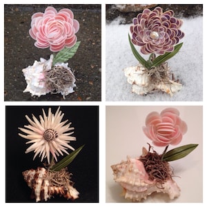 May include: Four different shell flower arrangements. Each arrangement features a different type of shell flower, including a pink rose, a purple flower, a white flower, and a pink flower. Each arrangement is placed in a seashell.