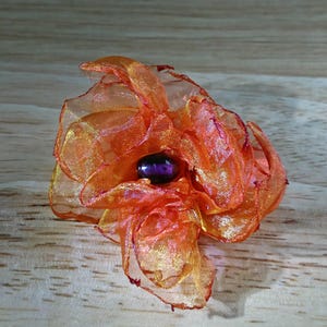 Red/orange iridescent organza flower pin with glass beading.