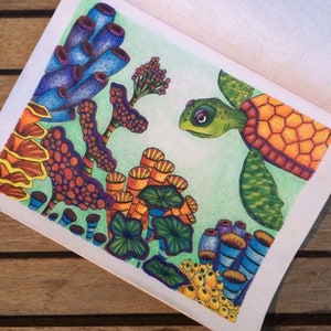 An example of a sea turtle amongst coral coloring page, using color pencils in bright green blues yellows and oranges.