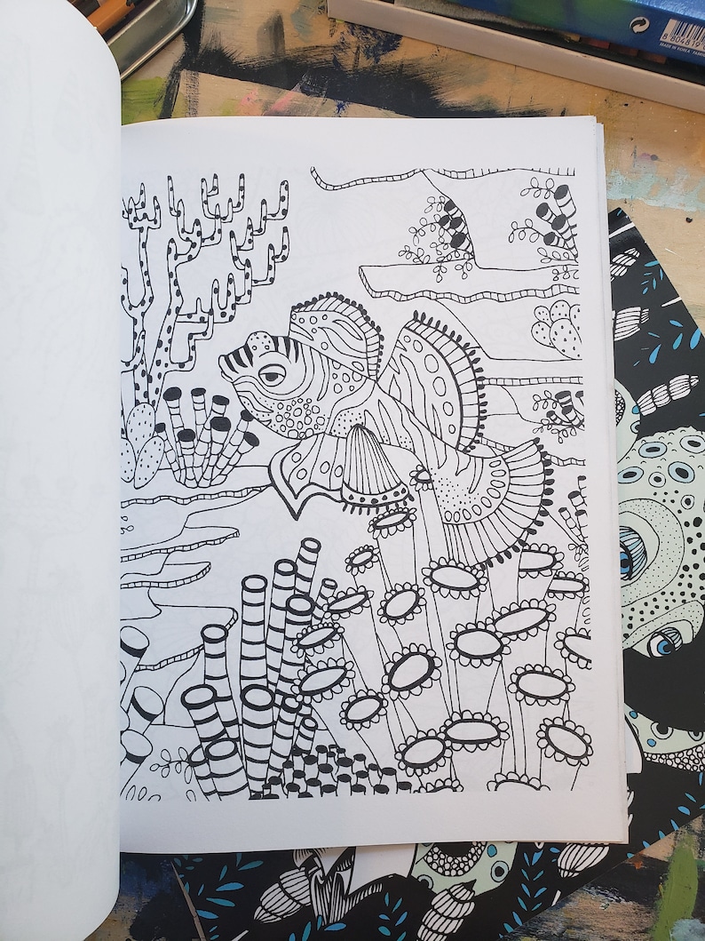 A coloring book page with mandarin fish swimming amongst sea vegetation