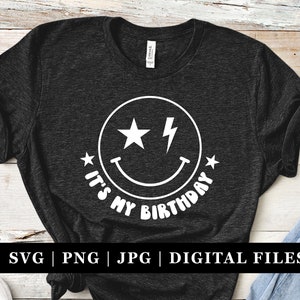 May include: A black t-shirt with a white smiley face with a lightning bolt and the text "It's My Birthday".