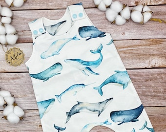 Könnte beinhalten: Ein weißer Baby-Strampler mit einem Aquarell-Druck von einem blauen Wal und anderen Meeresbewohnern. Der Strampler ist ärmellos und hat Druckknöpfe an den Schultern. Der Text "Peace Love & Embroidery" ist am unteren Rand des Stramplers sichtbar.