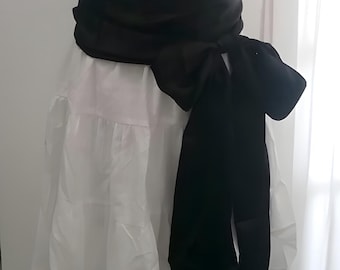 May include: White dress with a square neckline, short puff sleeves, and a tiered skirt. A wide black sash is tied around the waist, creating a defined silhouette. The dress is displayed on a mannequin.