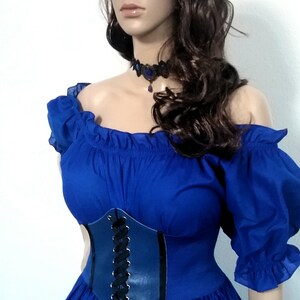 May include: A blue off-the-shoulder dress with a black lace-up corset and a blue gemstone necklace.