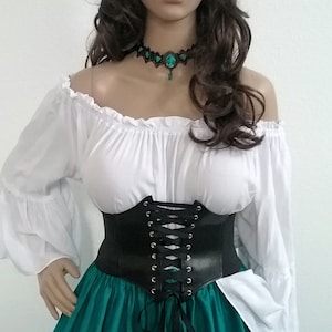 K&ouml;nnte beinhalten: Ein Outfit im Renaissance-Stil mit einer wei&szlig;en schulterfreien Bluse mit langen &Auml;rmeln, einem schwarzen Korsett und einem teal-gr&uuml;nen Rock. Das Ensemble wird durch einen Blumenkranz und einen passenden Choker erg&auml;nzt.