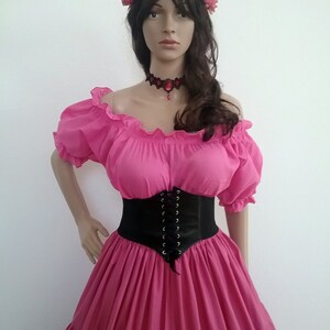 May include: A pink off-the-shoulder peasant top with a black corset belt and a pink flower crown. The top has a ruffled neckline and short sleeves.