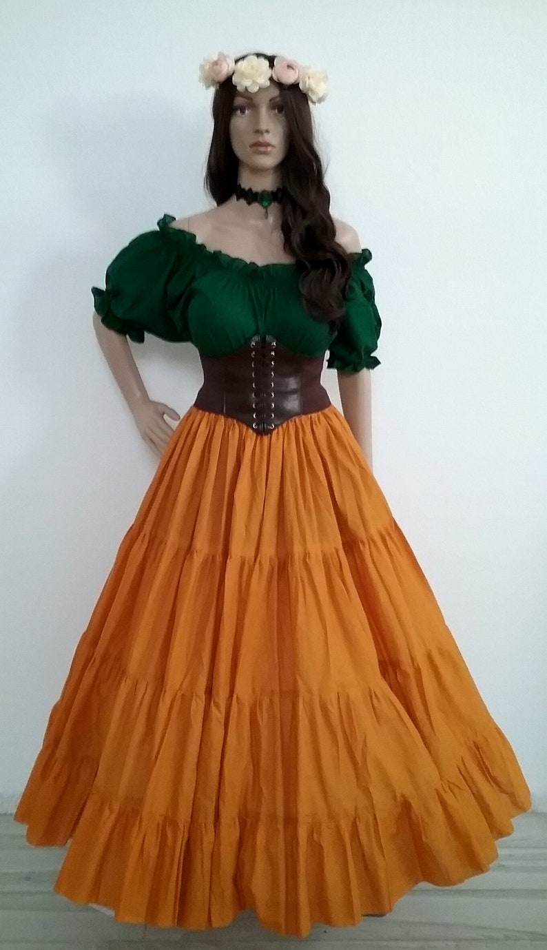 May include: A woman wearing a green off-the-shoulder peasant top with a brown leather corset and a long, tiered orange skirt.