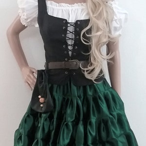 May include: A Renaissance-style costume featuring a black bodice with a laced front over a white blouse with puffy sleeves. The outfit includes a dark green, ruffled skirt, a brown belt, and a small black pouch. A mannequin wears the outfit.