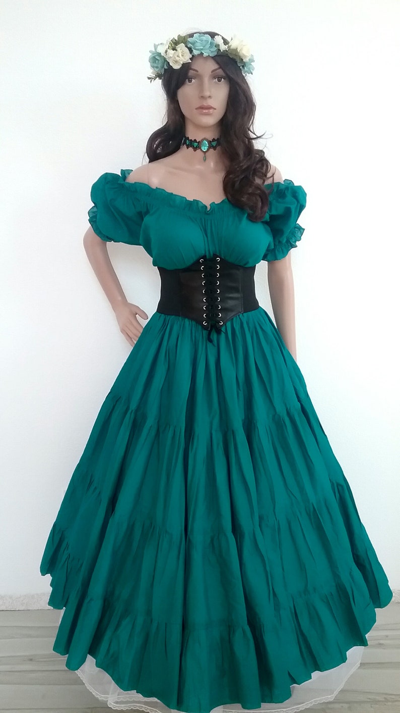 May include: A teal green dress with a black corset belt and a floral crown. The dress has a ruffled skirt and a fitted bodice.