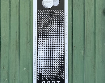 May include: A vertical 2027 Lunar Phase Calendar printed on a black background with white text and moon phase illustrations. The calendar displays months from January to December, days 1 through 31, and notes for Lunar Perigee and Apogee.