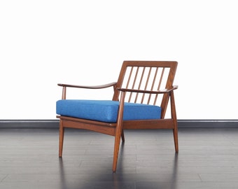 May include: A mid-century modern armchair with a blue fabric cushion and a wooden frame. The chair has a slatted back and angled legs.
