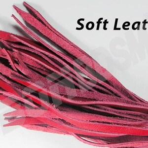 May include: A close-up of a bundle of soft, red leather strips. The strips are arranged in a fan shape and have a slightly textured surface. The text "Soft Leather" is visible in the upper right corner of the image.