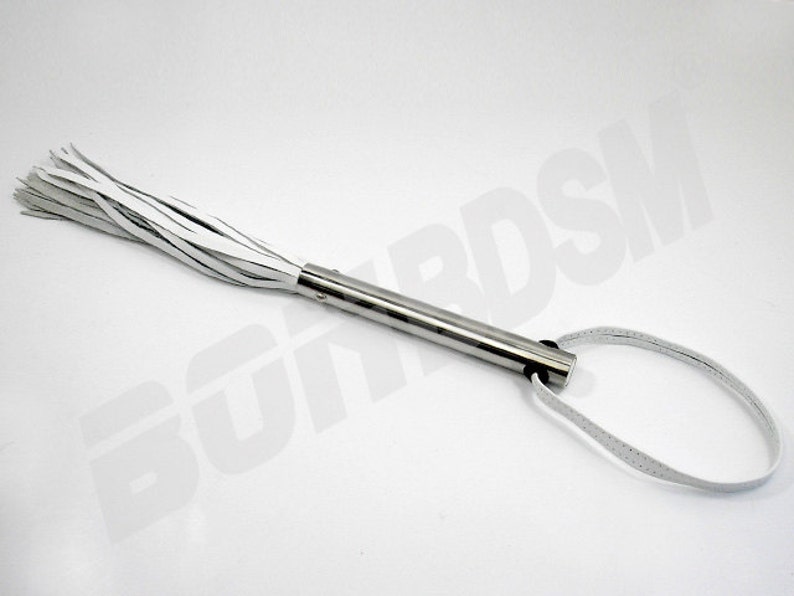 May include: A white leather whip with a silver handle and a loop at the end.