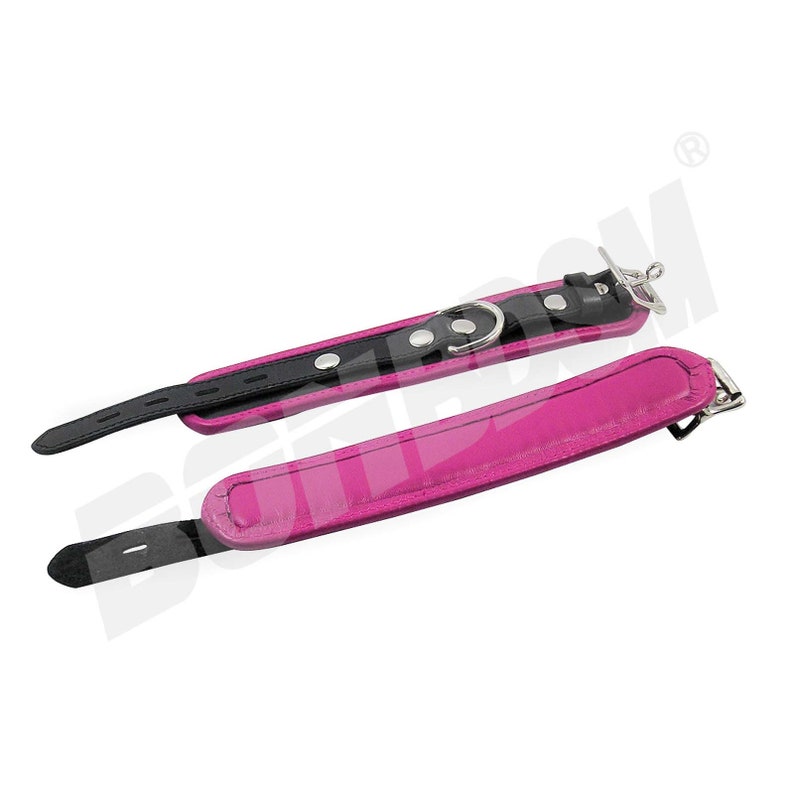 May include: A set of two pink leather collars with black trim and silver hardware. One collar has a buckle closure and the other has a D-ring.