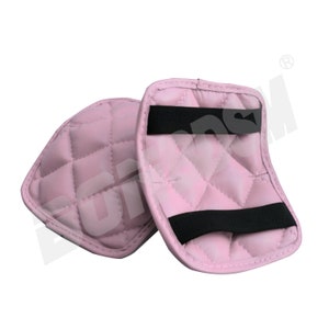 May include: Two pink quilted knee pads with black elastic straps. The knee pads are designed for comfort and protection.