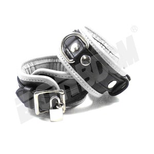 May include: Black leather cuffs with a white leather trim and a silver lock. The cuffs are connected by a silver chain.