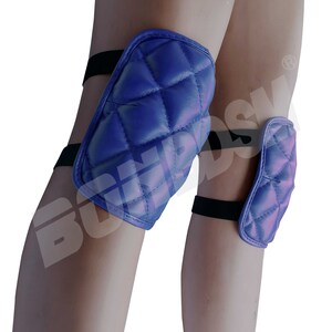 May include: A pair of blue quilted knee pads with black elastic straps. The knee pads are designed to protect the knees from injury.