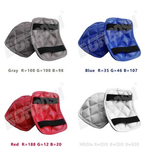 May include: Four pairs of elbow pads in different colors: gray, blue, red, and white. Each pair has a quilted design and a black strap.