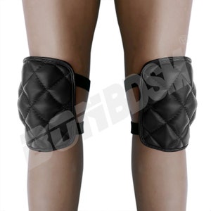 May include: A pair of black quilted knee pads with adjustable straps. The pads are designed to provide protection and comfort for the knees.