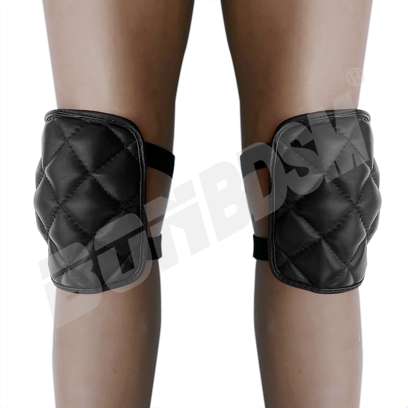 May include: A pair of black quilted knee pads with adjustable straps. The pads are designed to provide protection and comfort for the knees.