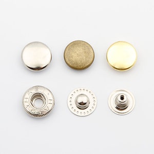 May include: A set of six metal snap buttons in three different finishes: silver, brass, and gold. The buttons are round and have a flat top. The set includes two snap button pieces for each finish.