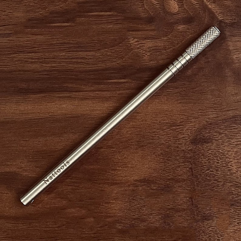 May include: A silver metal tool with a textured handle and the word "Nattools" engraved on the side.