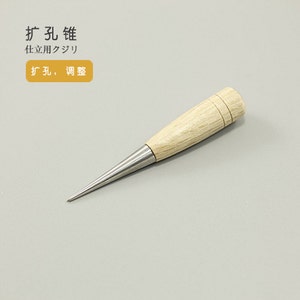 May include: A wooden-handled awl with a sharp, pointed metal tip. The handle is light brown and has two rings around it. The text "打孔 錐" is visible in the image, which translates to "punching awl" in English.