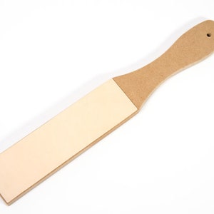 以下が含まれることがあります： 木製のハンドルが付いた薄い茶色の革製の砥石。砥石はナイフを研ぐために使用されます。