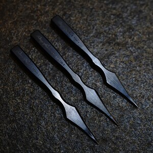 Può includere: Tre strumenti in metallo nero con punte appuntite. Gli strumenti sono etichettati con le loro dimensioni: 3,86 mm, 3,3 mm e 2,7 mm.