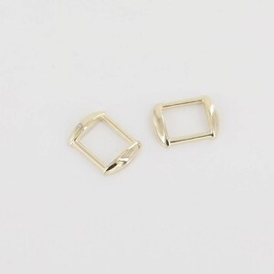 May include: Two gold-toned metal slider buckles, one rectangular and one square.