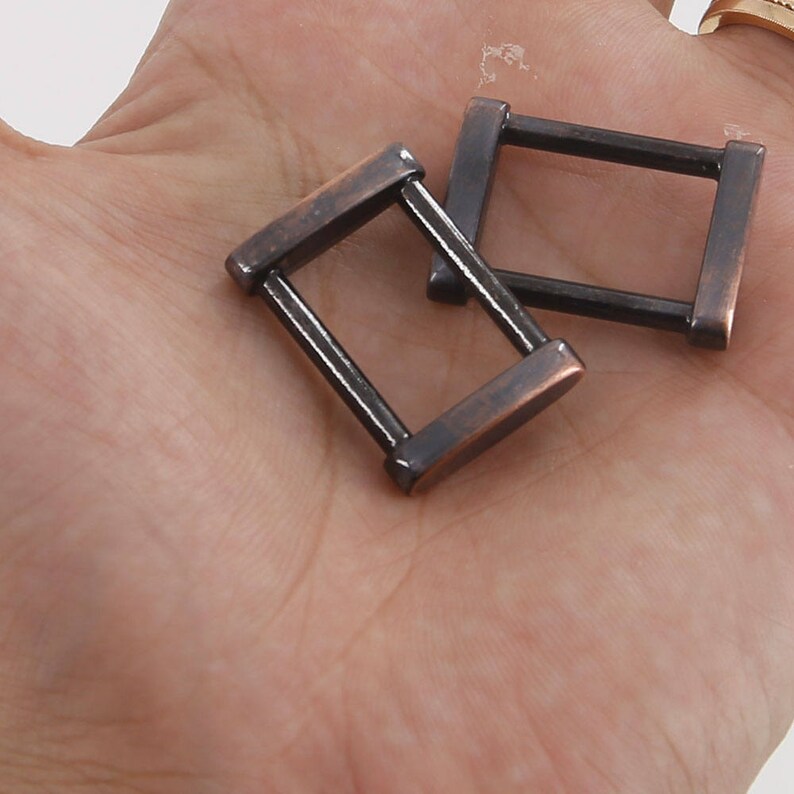 K&ouml;nnte beinhalten: Zwei antike goldfarbene D-Ringe aus Metall. Die Ringe haben einen Durchmesser von etwa 2,5 cm und eine glatte, polierte Oberfl&auml;che.