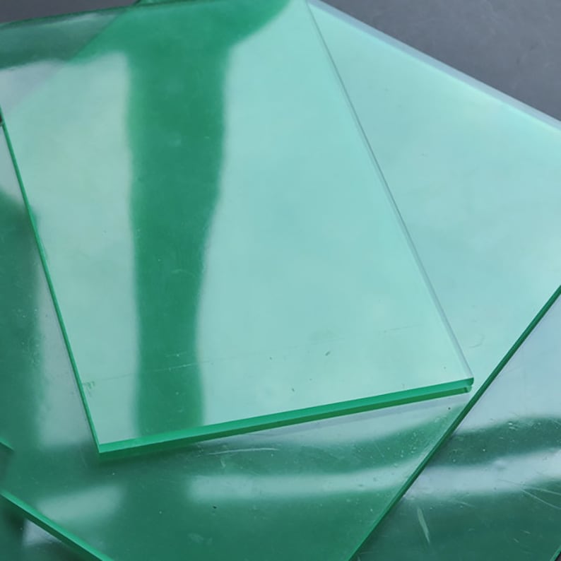 Peut inclure: Pile de trois feuilles d'acrylique transparentes de couleur verte. Les feuilles sont translucides et ont un l&eacute;ger &eacute;clat.