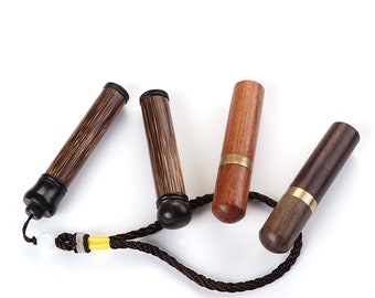 Puede incluir: Cuatro estuches de agujas de madera con un cordón negro y una cuenta de jade. Los estuches están hechos de diferentes tipos de madera, incluyendo marrón oscuro, marrón claro y marrón rojizo.