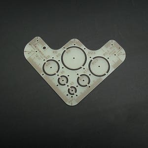 May include: A clear plastic template with a variety of circle sizes for drawing or cutting. The template includes circles with diameters of 5.0, 6.0, 7.5, 10.0, 12.5, and 15.0 centimeters.