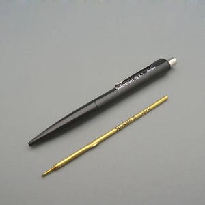 May include: A black ballpoint pen with the text "Schneider S.K.1 Germany" printed on the side. A gold refill is also shown.