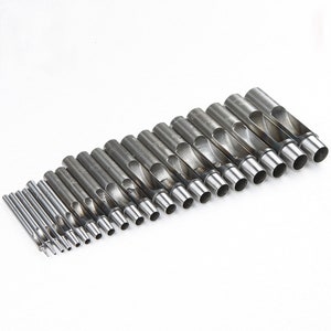 May include: A set of 18 silver metal hole punch tools of varying sizes. The tools are arranged in a row from largest to smallest.