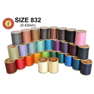 Puede incluir: Una colección de 25 carretes de hilo de lino encerado en varios colores. Los carretes están dispuestos en forma de pirámide. El hilo es de tamaño 832 (0,43 mm).