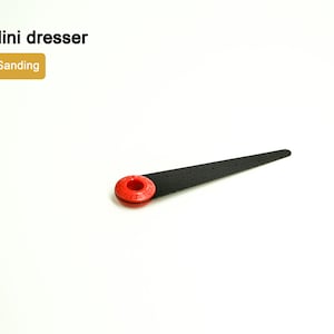 Puede incluir: Un mini-vestido negro con un mango de plástico rojo. El vestido se utiliza para lijar.