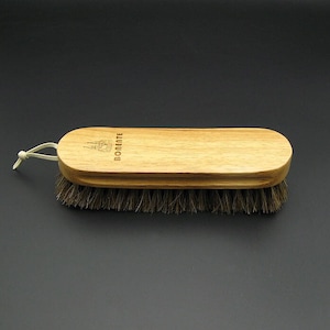 Könnte beinhalten: Eine Schuhbürste aus Holz mit einer braunen Borstenbürste und einem Holzgriff. Der Griff trägt den eingravierten Text "Boenente".