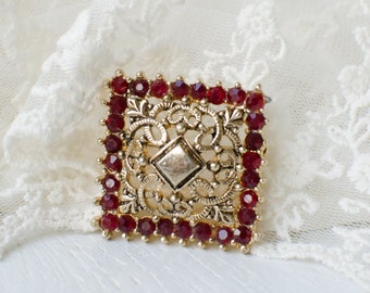 Openwork square vintage brooch with red crystals