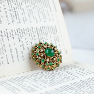 Green vintage round filigree openwork brooch with glass cabochon
