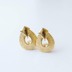 Vintage gold tone vintage clip-on earrings in shield shape